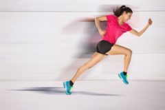 young woman jogging front cement wall